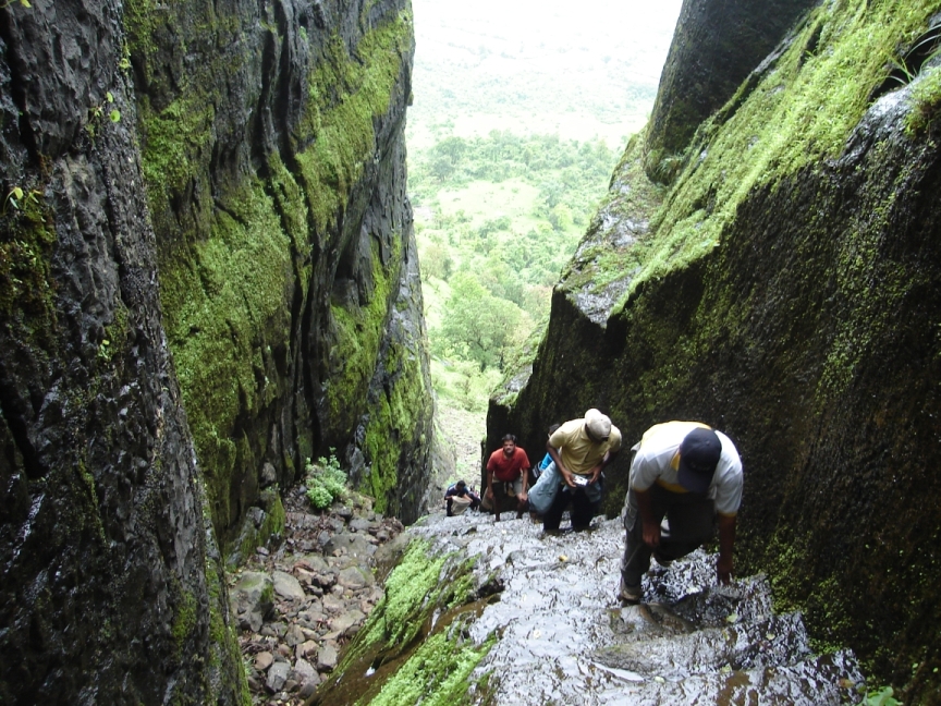 Hikers climbing wet stone steps at Sudhagad Fort in Raigad.